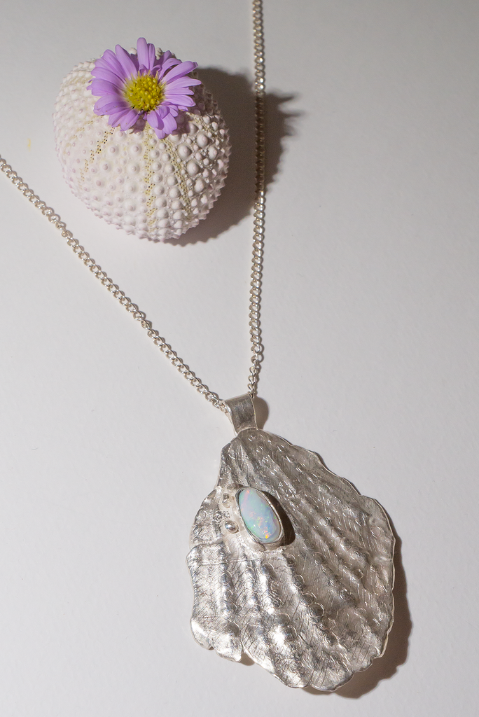 The pendant is solid silver, it is cast from an old sea worn shell and has a beautiful Australian opal set onto the front. This pendant is totally unique, it has the feeling of the spirit of the ocean