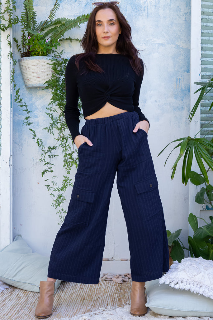 The Traveller Sonar Blue Pants are a beautiful navy blue pair of mid-rise cargo style pants. The pants feature an elasticated waist, side pockets, wide legs, and patch pockets. Made from 100% cotton.