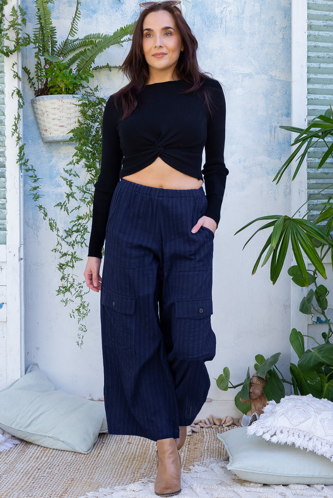 The Traveller Sonar Blue Pants are a beautiful navy blue pair of mid-rise cargo style pants. The pants feature an elasticated waist, side pockets, wide legs, and patch pockets. Made from 100% cotton.