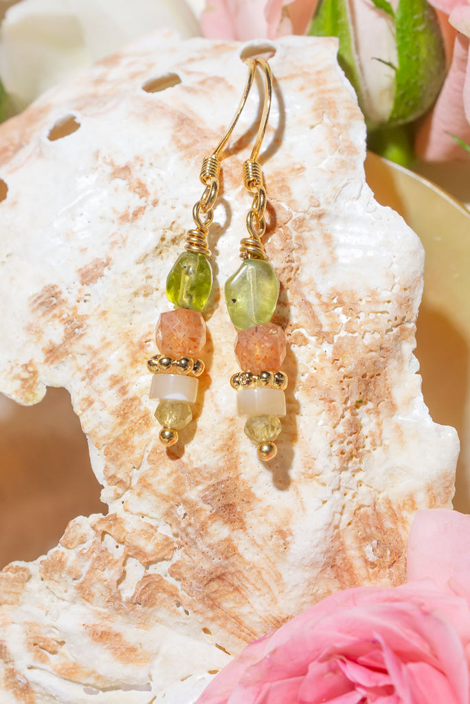 The Earrings Golden Droplet Peridot are a gorgeous pair of handmade earrings featuring periodic, natural sunstone and mother of pearl.