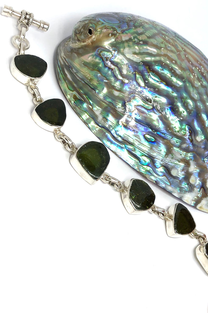 Echo Bracelet Tourmaline Green, each of the six stones  has been individually set and rim set into 925 silver.  The stones are all cut and polished into different shapes and linked in 925 silver.