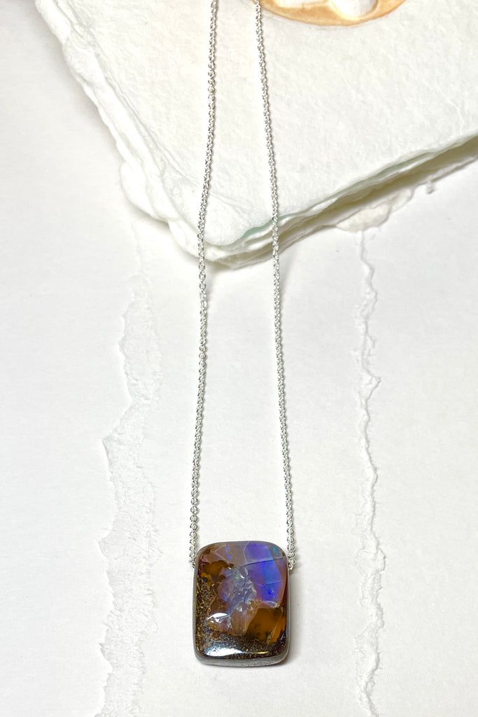 Comes on a silver snake chain. A very organic natural piece of Boulder Opal with a flash of crystal across the top. The surface of the piece is not completely flat.