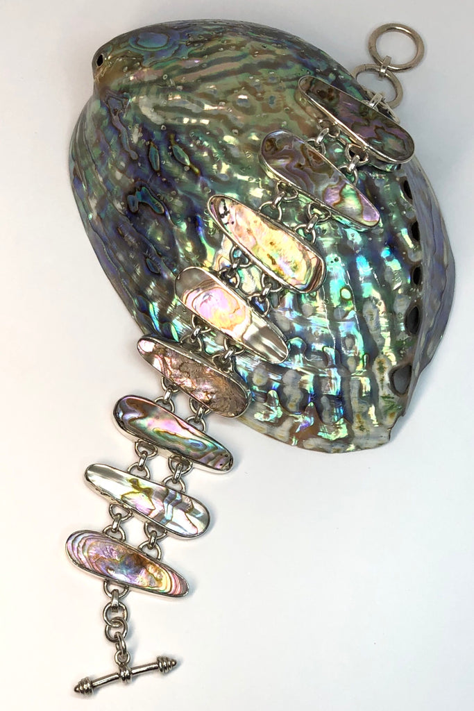 The Echo Bracelet Paua Sea has each link cut to enhance the gorgeous colours and each shape individually set and rim set into 925 silver.