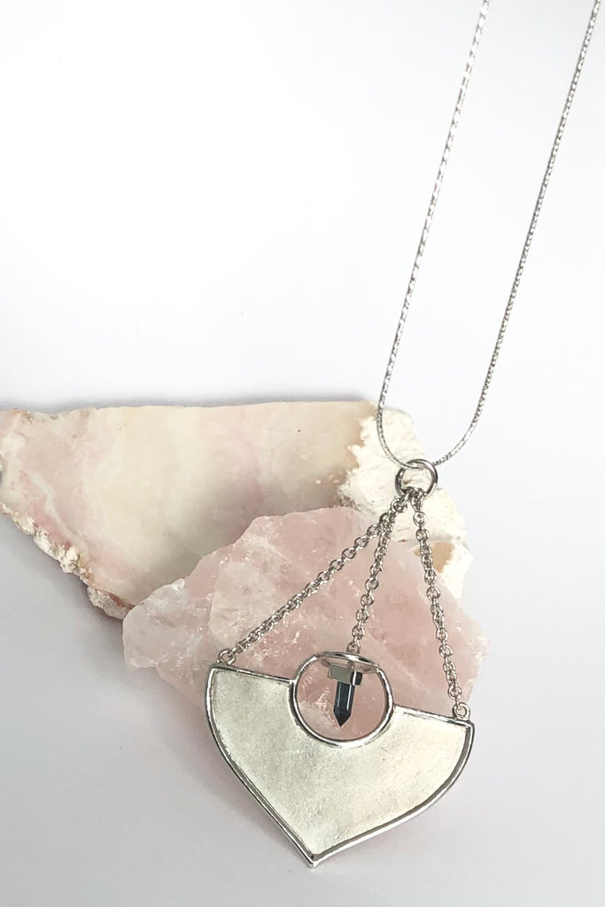 A stunning African Style 925 silver pendant with a Tourmaline Shard which hangs perfectly through a silver circle. The intense blue Tourmaline was sourced ethically from miners in Nigeria,