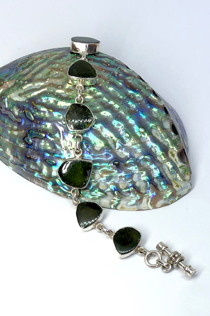 Echo Bracelet Tourmaline Green, each of the six stones  has been individually set and rim set into 925 silver.  The stones are all cut and polished into different shapes and linked in 925 silver.