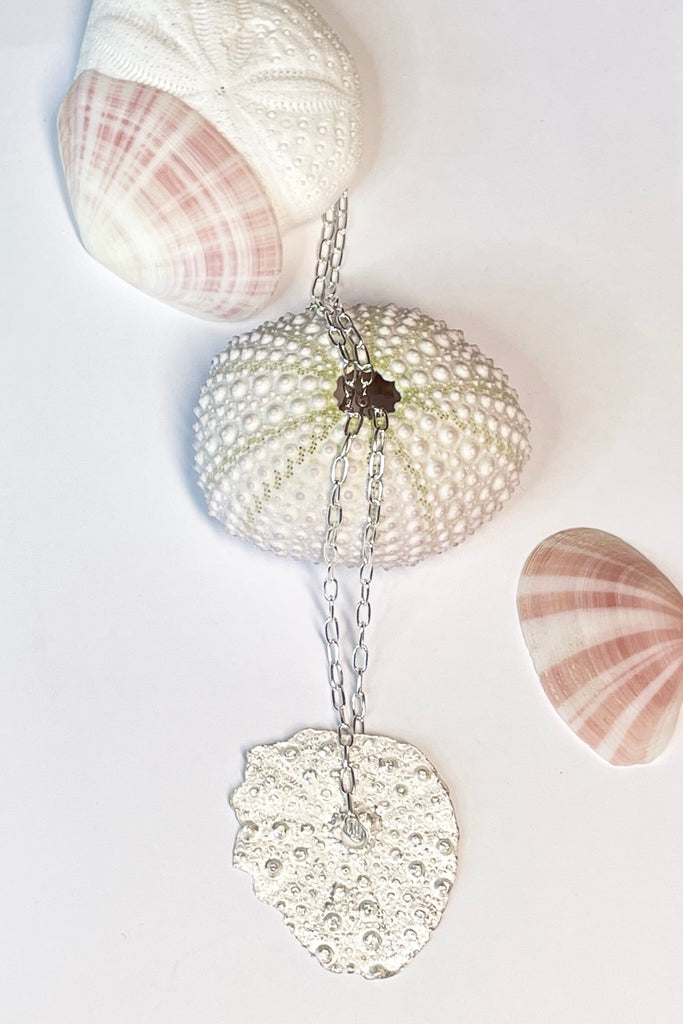 . The centre piece is silver, it is cast from a sea urchin shell. This pendant  is so delicate and has the feeling of a tiny sparkly shard floating in the ocean. 