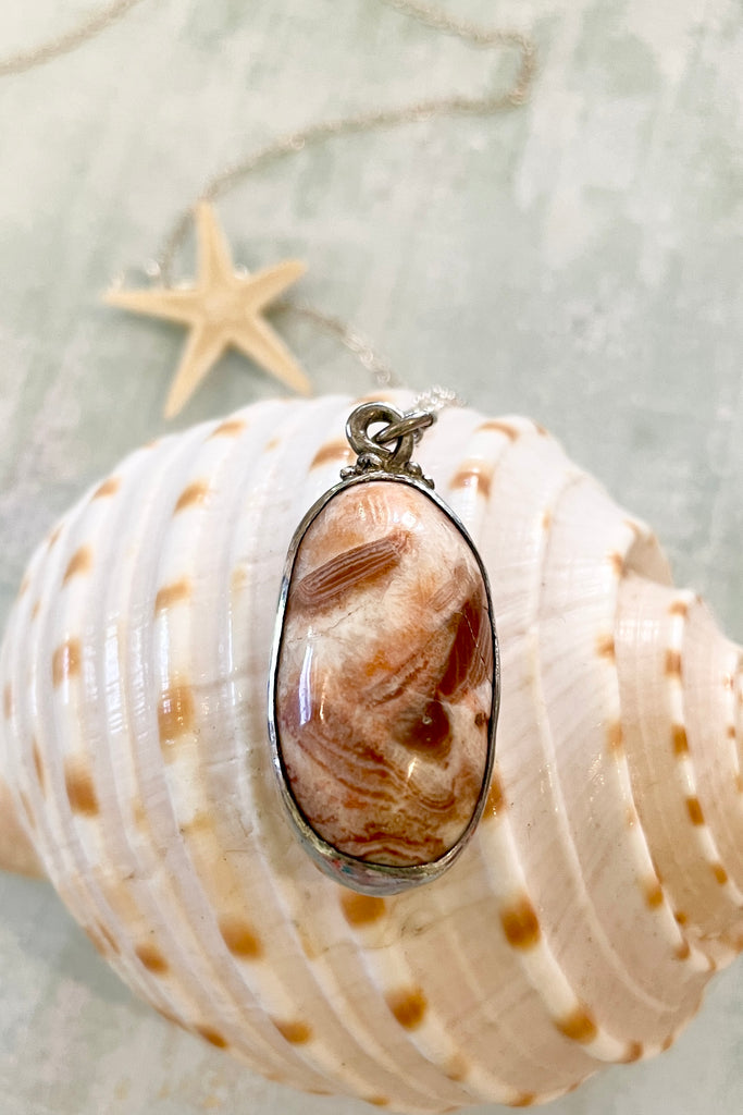 pendant features a very pretty polished stone. It comes on a silver chain.
