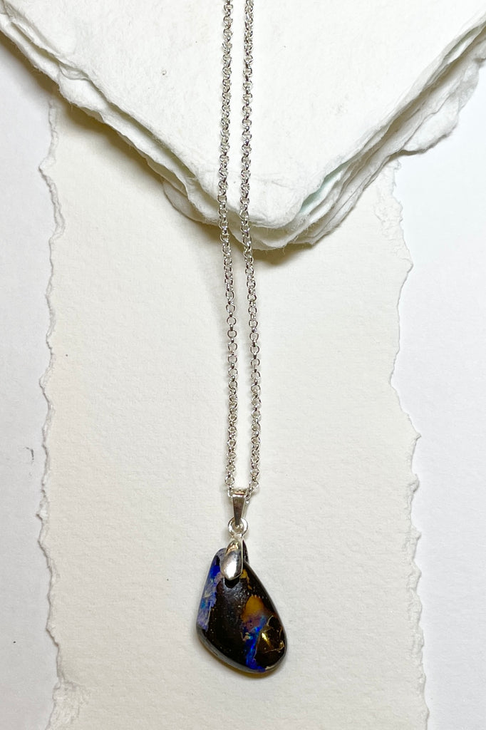 A tiny organic triangular piece with deep flashes of dark blue and crystal through the piece. Perfect entry level Opal.