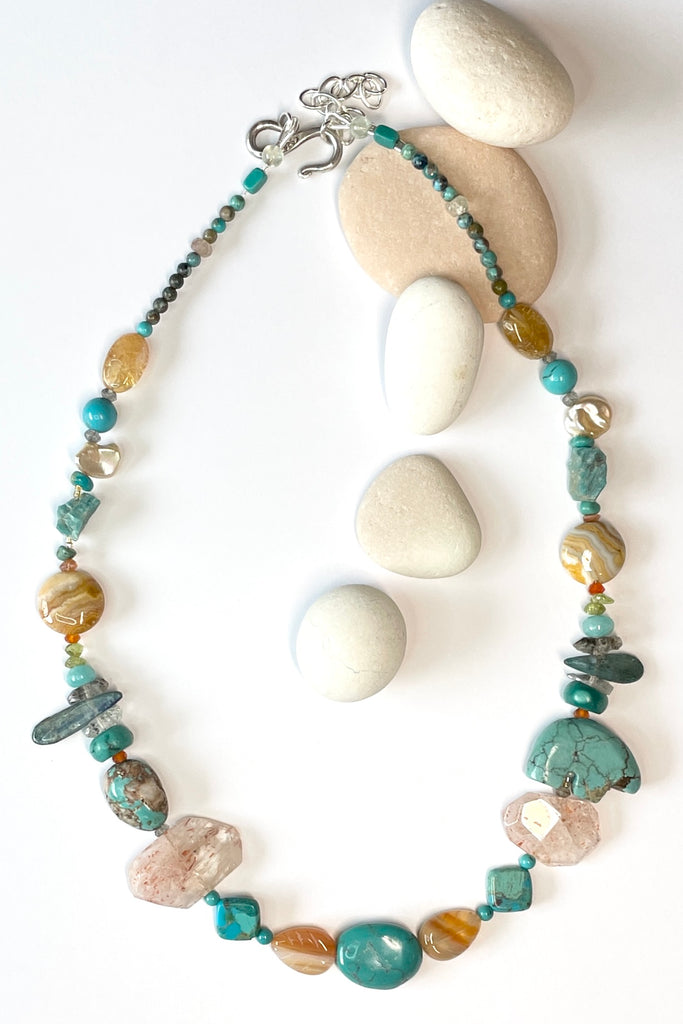 The necklace features a hand carved Zuni bears bought in Taos new Mexico. Stones are Natural Turquoise, Herkimer Diamond, Kyanite rough shards, Pearl, natural Sunstone, Strawberry Quartz, Banded Agate, Peridot and Labradorite .