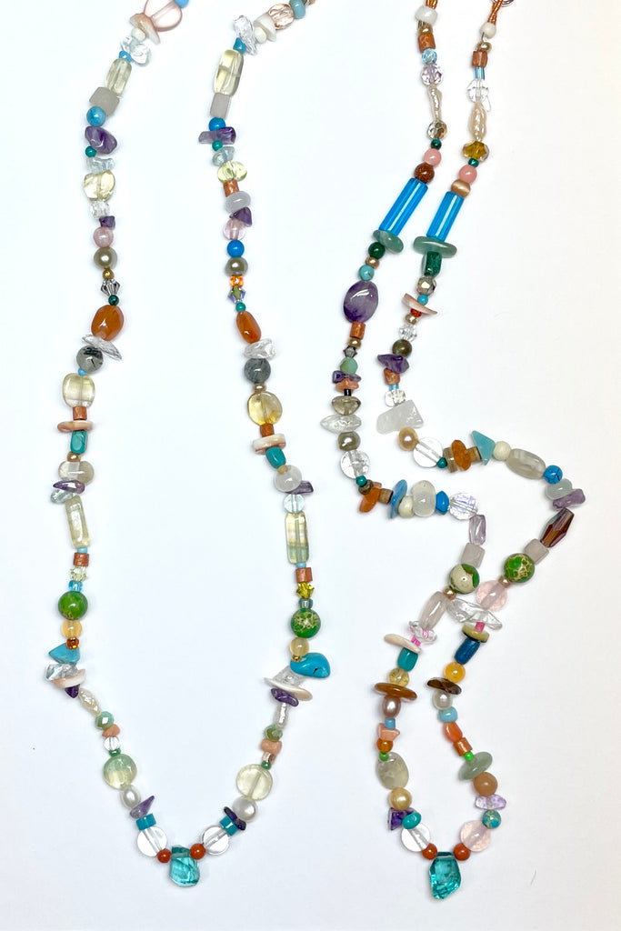 Our necklace Cay Precious is a sweet choker style hand made using random choice of gemstones, crystal, glass and shell beads in subtle mix of pretty colours. The centrepiece is a tiny bright turquoise apatite "Geo Cut" stone. 