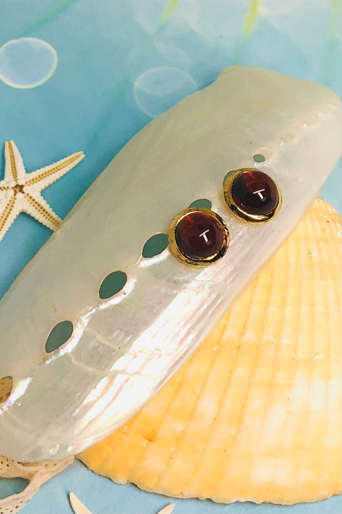 A cabochon dome of gemstone with a daisy pattern surround. Rose Gold vermeil or 925 silver setting.