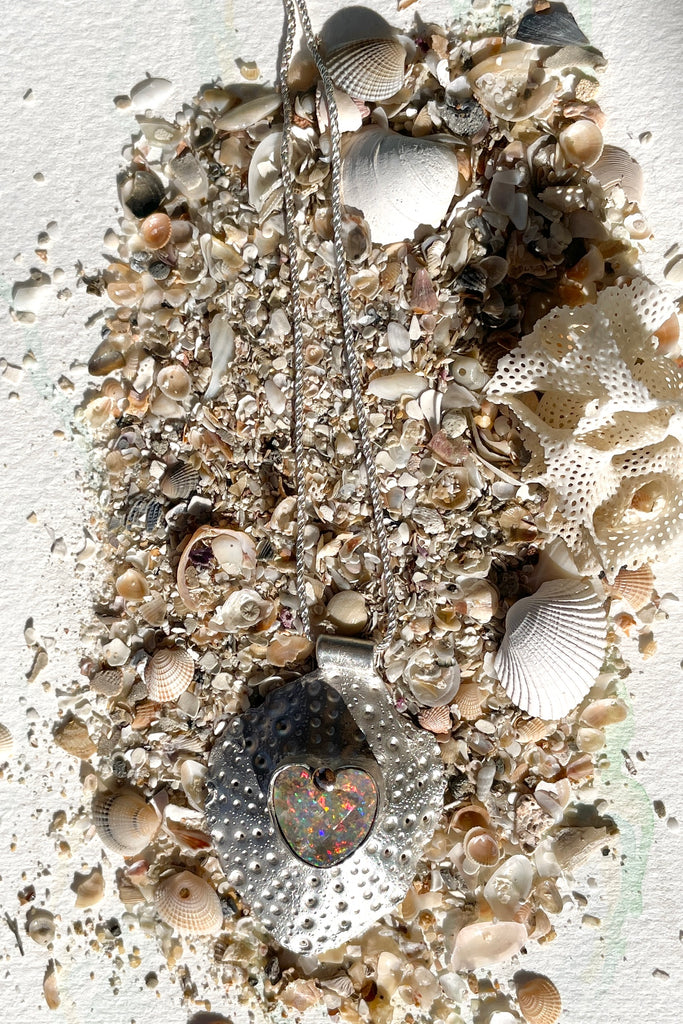 The heart opal centre piece is cut from natural solid Australian Opal. The silver is moulded from the shell of a sea urchin, then the opal is applied with the aid of a small gold dot of repurposed 18ctgold.