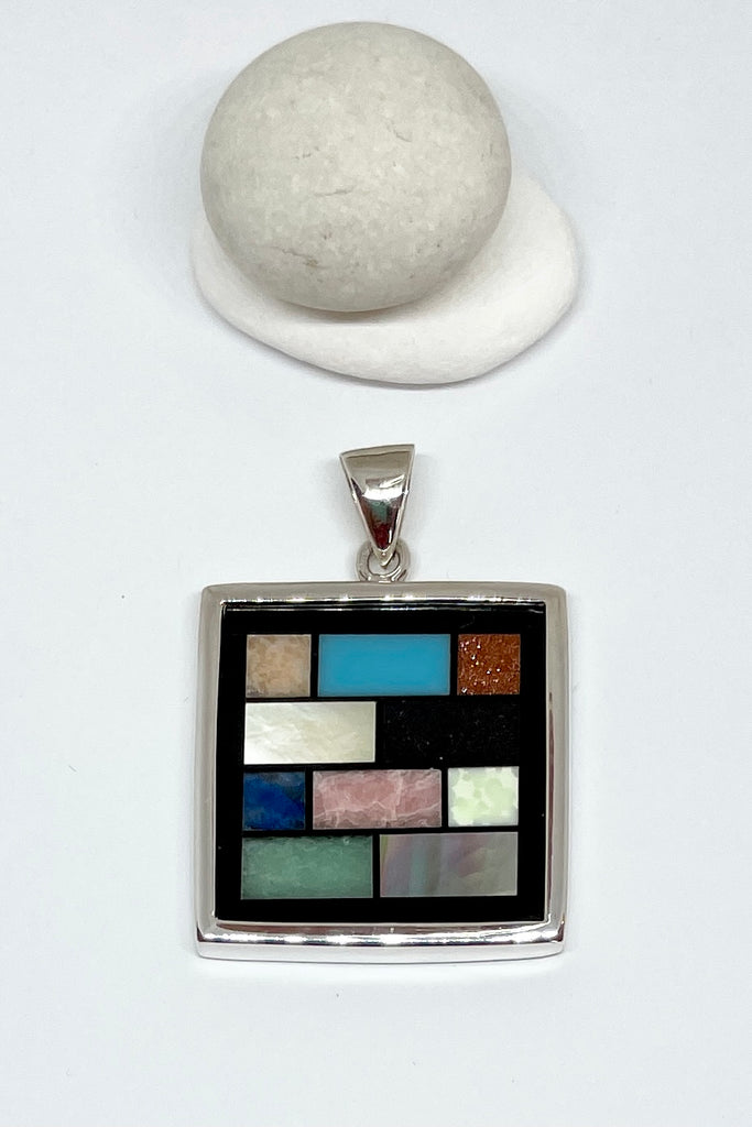 This amazing silver and shell inlay pendant is completely unique and handmade. Inspired by the colours of  on an Ndebele African house paint design, each piece is slightly different, the mosaics are in the same order but stone patterns may vary.