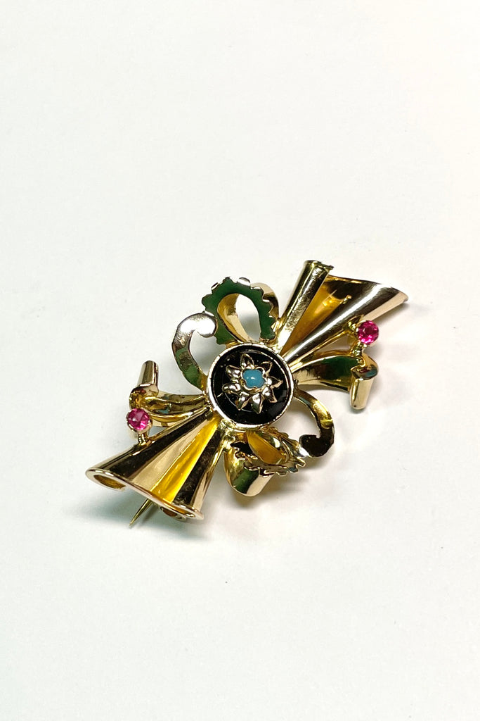 the brooch is unmarked gold with two tiny pink stones either pink garnet or ruby, the centre is black onyx with a star that has a turquoise centre stone.
