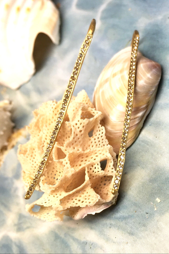 The name is Earth Moon, the style is inspired by tiny slivers of moonlight lighting the golden beach sand. Made in gold vermeil and tiny sparkling white topaz gemstones, the finish is quiet and naturalistic, the surface is matte. 