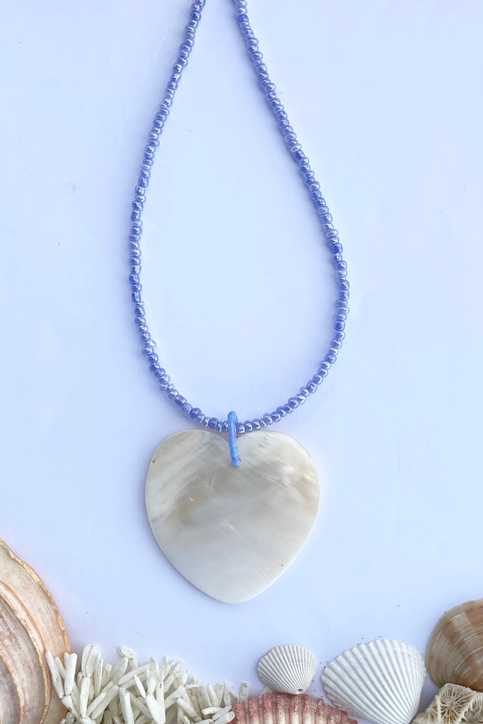 heart is hand carved from Mother of Pearl shell, each heart carries the distinctive marks of the artist who created it, no two shells are ever alike,  strung on pearlescent pale mauve glass beads.