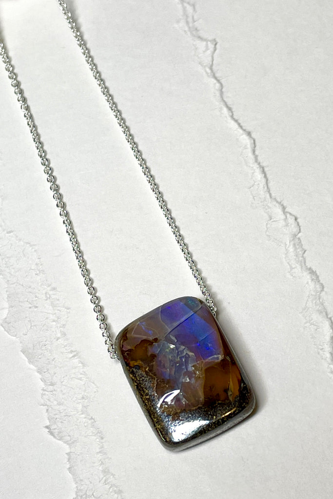 Comes on a silver snake chain. A very organic natural piece of Boulder Opal with a flash of crystal across the top. The surface of the piece is not completely flat.