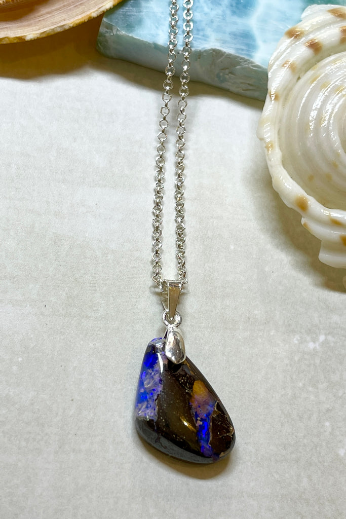 A tiny organic triangular piece with deep flashes of dark blue and crystal through the piece. Perfect entry level Opal.