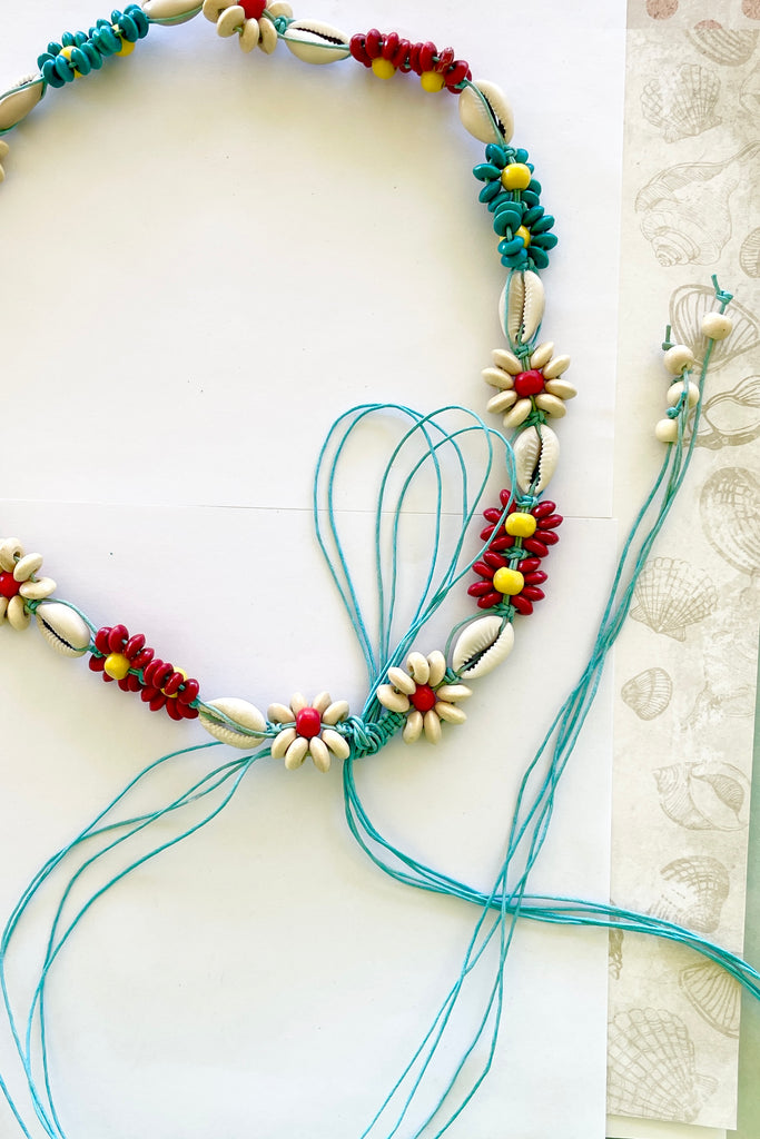 Tie belt with wood beads and cowrie shells.