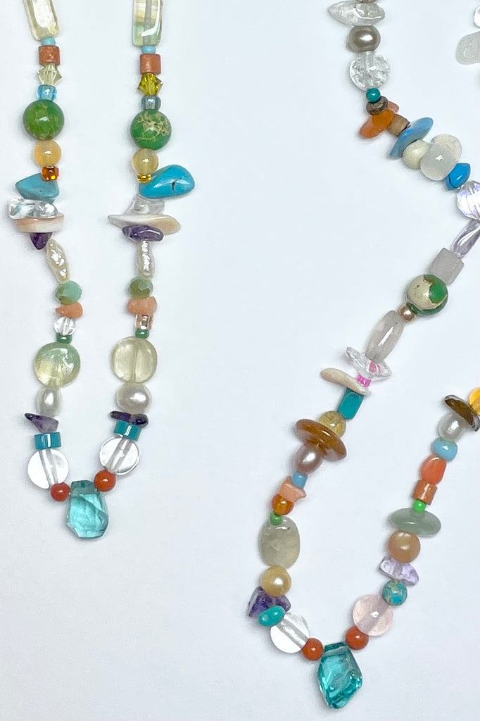 Our necklace Cay Precious is a sweet choker style hand made using random choice of gemstones, crystal, glass and shell beads in subtle mix of pretty colours. The centrepiece is a tiny bright turquoise apatite "Geo Cut" stone. 