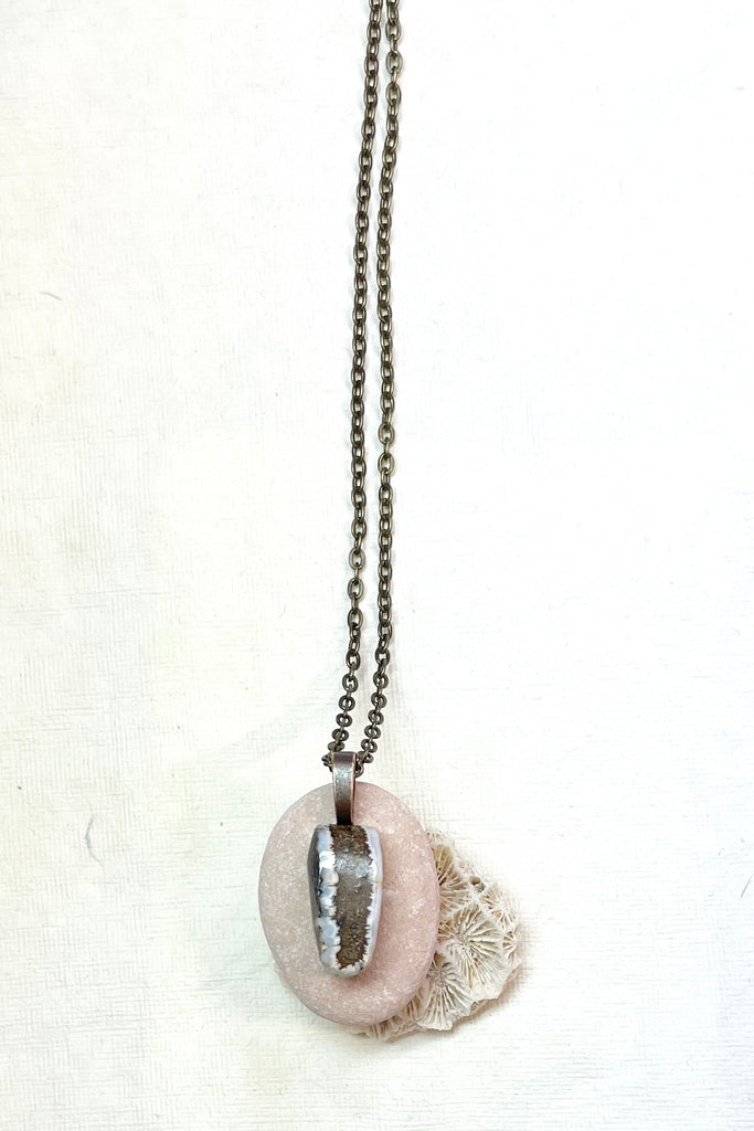  The pendant has a band of rock running down the centre and the edges have a crystalline opal edge.