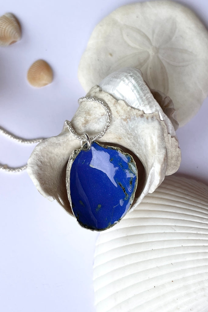  The centre piece is silver, it is cast from a little shell picked up on the Noosa beach. This pendant  is so quiet and it has a secret, the underside is enameled in deep sea blue, with a scattering of sand and rocks around the edge