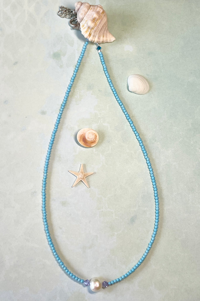  A delicate choker style necklace made with tiny sand seed beads, with a pearl and Swarovski crystal centre piece.