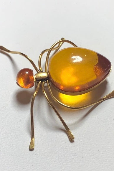 Features the form of a six legged bug with the head and body set with cabochons of natural Baltic honey amber. Marked on underside. A super quirky insect brooch