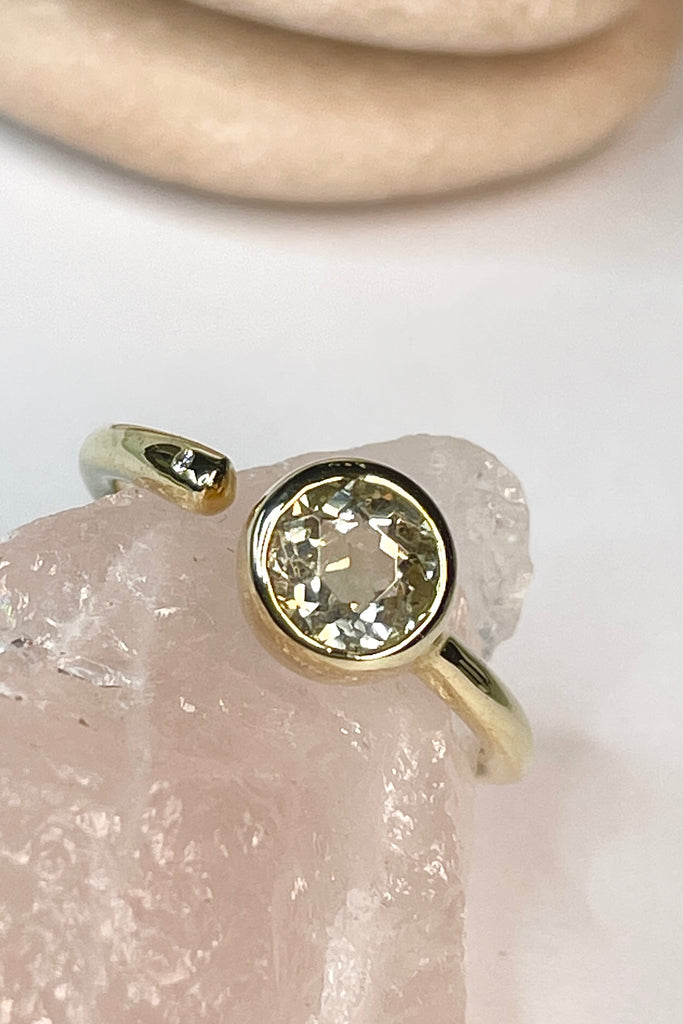 this stunning 10k gold ring is set with a beautiful untreated soft yellow Nigerian Tourmaline offset by a sparkling 1pt Diamond. The setting features a band that ends before the stone, leaving a tiny gap enhanced with a diamond.