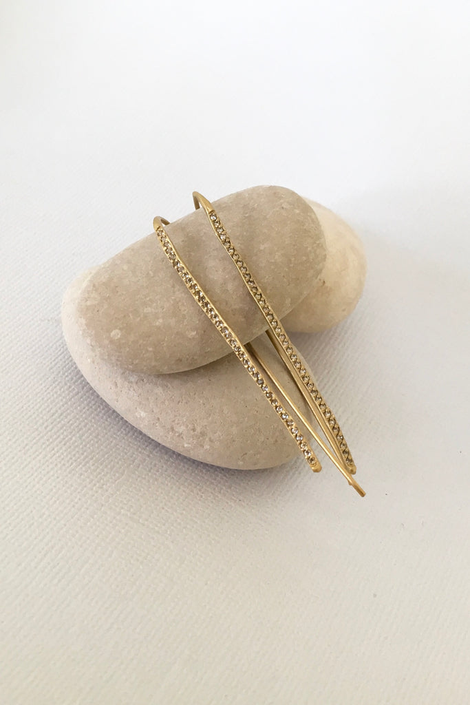 The name is Earth Moon, the style is inspired by tiny slivers of moonlight lighting the golden beach sand. Made in gold vermeil and tiny sparkling white topaz gemstones, the finish is quiet and naturalistic, the surface is matte. 