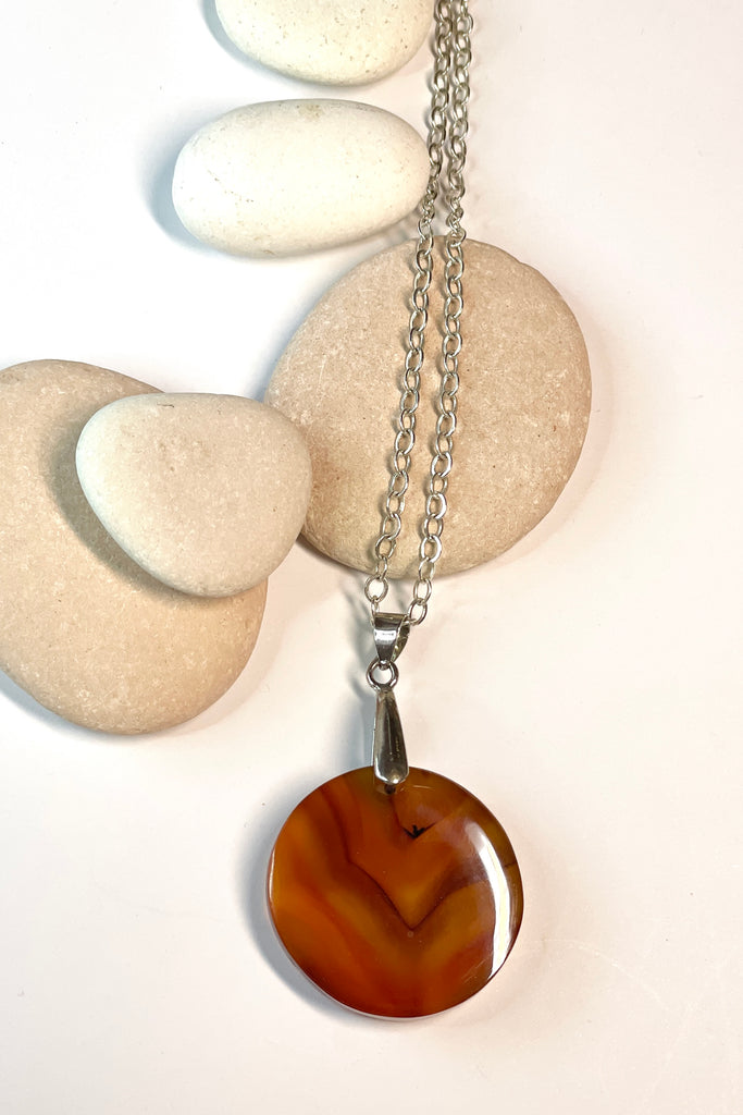 This pendant is a lovely piece of clear and rusty orange Agate stone that has been skillfully cut into a perfect circle then polished, by ROAM Ladies Lapidary Collective in Sakaraha, Madagascar. 