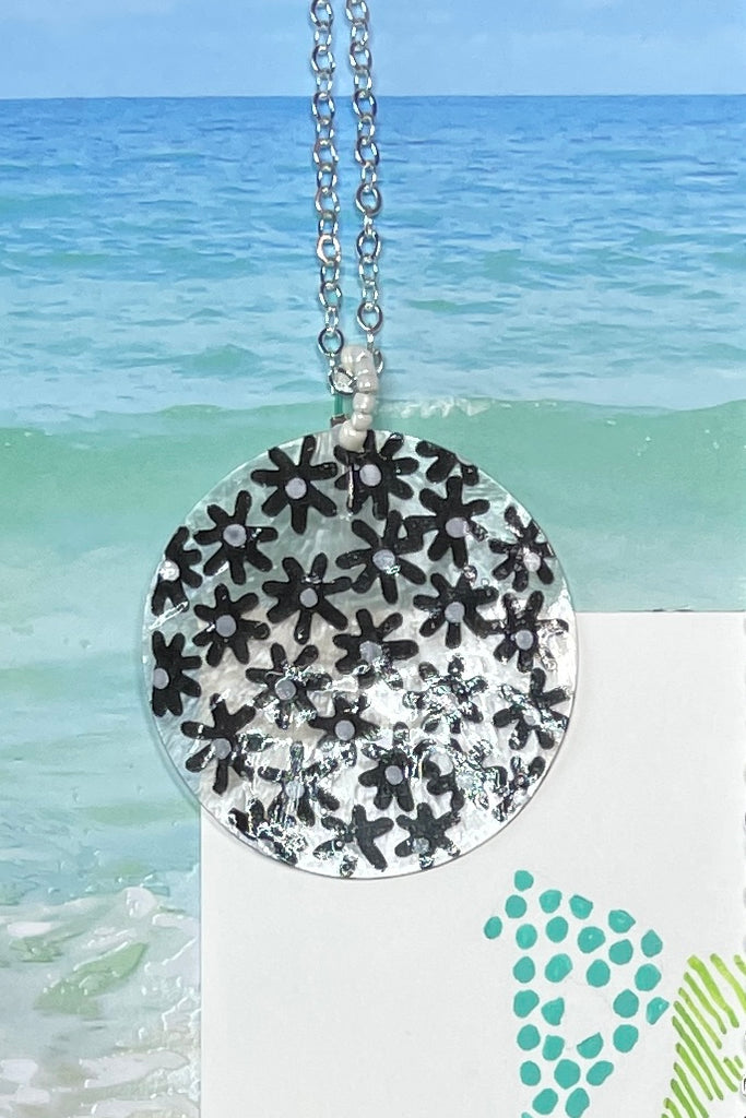 sweetheart daisy necklace is a Capiz shell circle hand painted with 60's style daisies