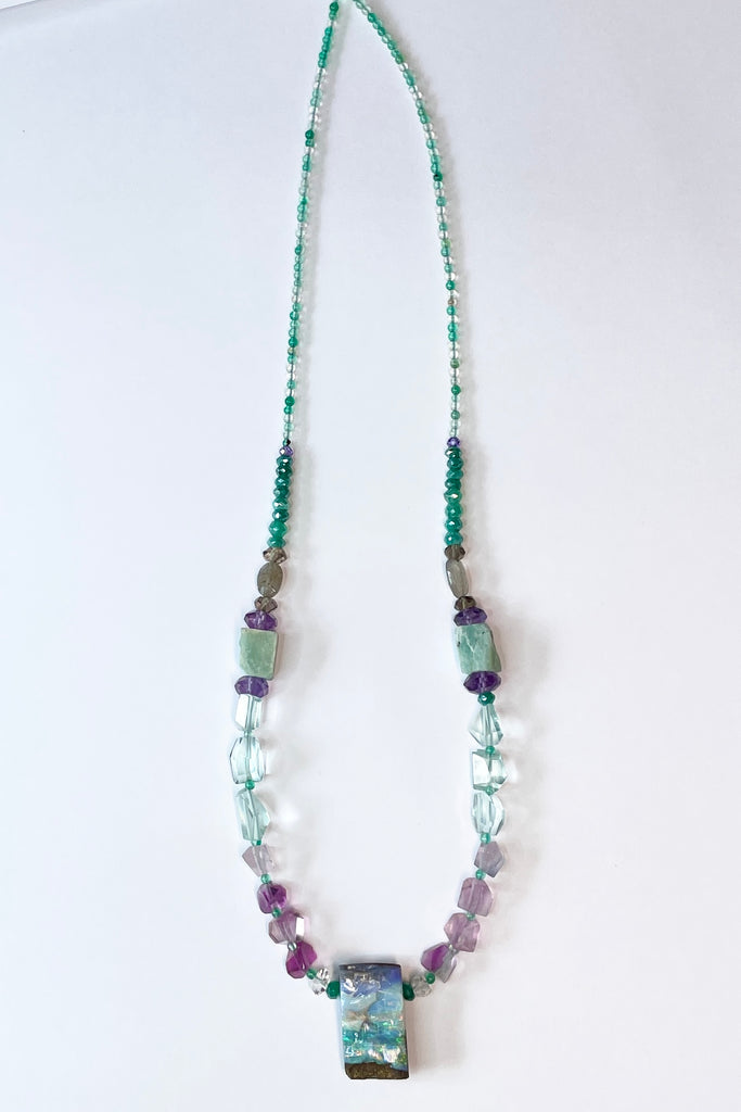 Opal necklace  The centrepiece is cut from an opal "split" so the surface is not polished but left exactly as it has been for millions of years. the back and sides are curved and polished to a soft shine. Bright flashes of crystal blue, green and mauve 