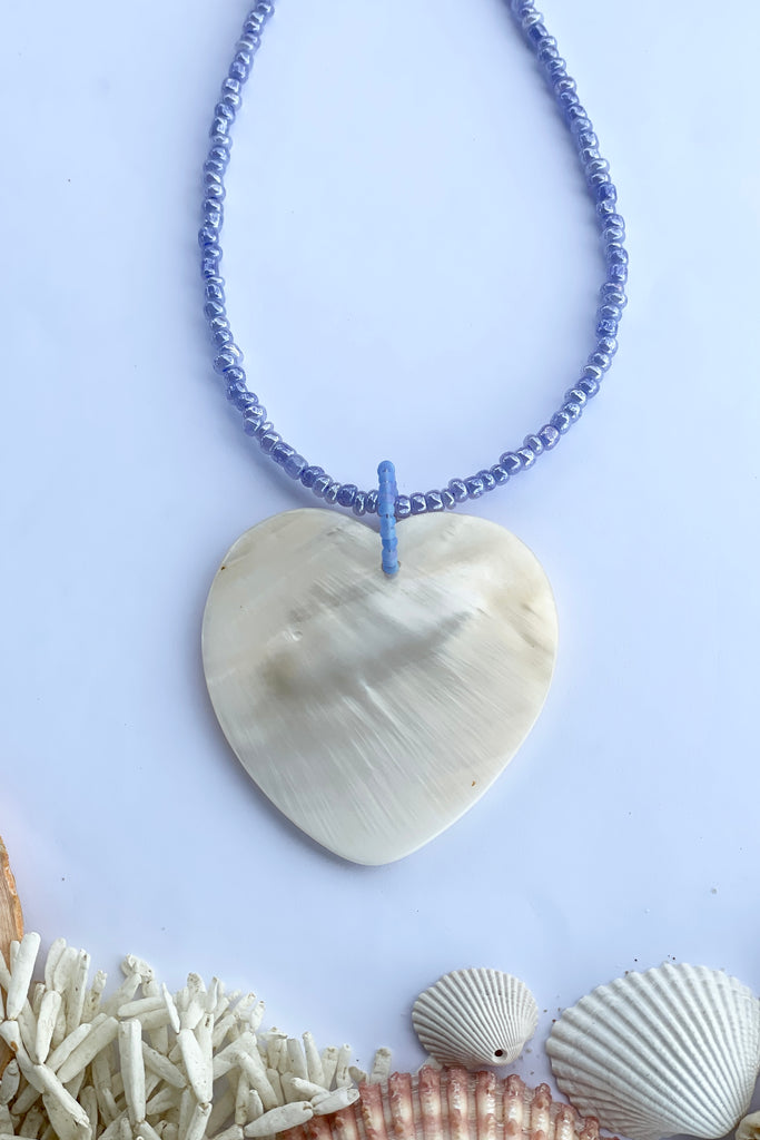 heart is hand carved from Mother of Pearl shell, each heart carries the distinctive marks of the artist who created it, no two shells are ever alike,  strung on pearlescent pale mauve glass beads.