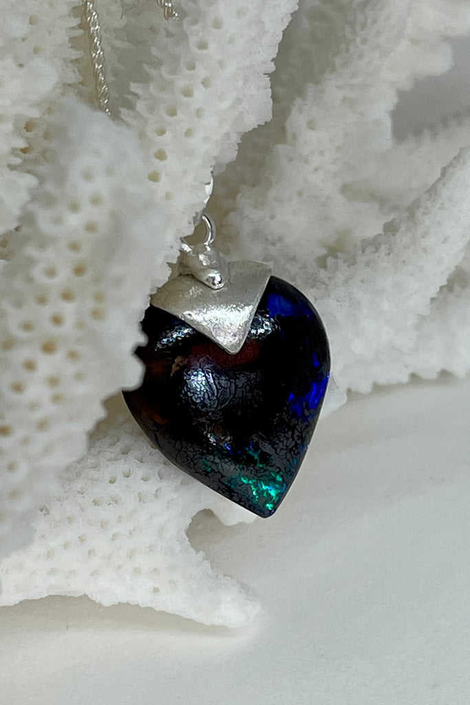  This intriguing and unique piece of opal was cut and polished into the heart shape for Mombasa Rose in Noosa, Queensland. The bright flashes of turquoise, teal and blue colour are very intense and deep in the stone, giving it a flashing twinkling look.  Very beautiful when viewed in sunlight. A very chic and modern opal pendant design. 