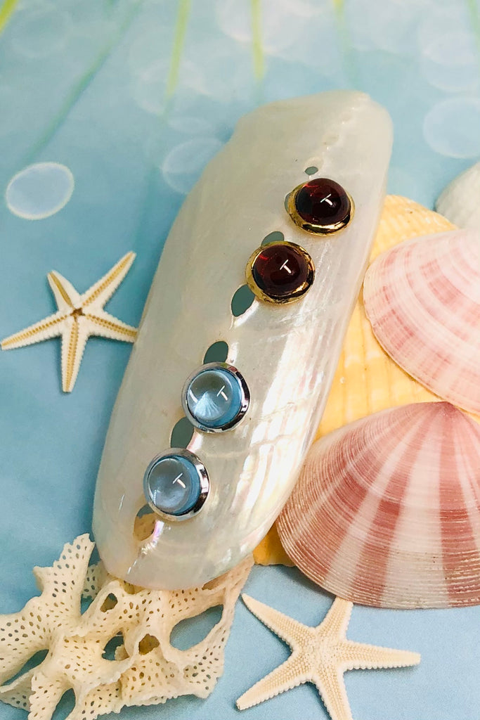A cabochon dome of gemstone with a daisy pattern surround. Rose Gold vermeil or 925 silver setting.