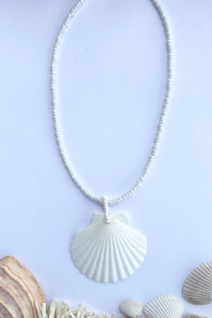 this gorgeous simple shell is almost pure white some have very pale pink markings, no two shells are ever alike,  strung on pearlescent white glass beads.