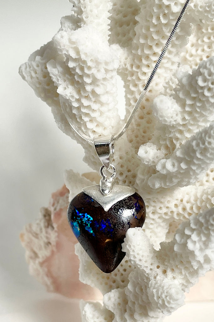 This intriguing and unique piece of opal was cut and polished into the heart shape for Mombasa Rose in Noosa, Queensland. The flashes of turquoise and teal go across and deep into the stone, giving it a flashing twinkling look. 