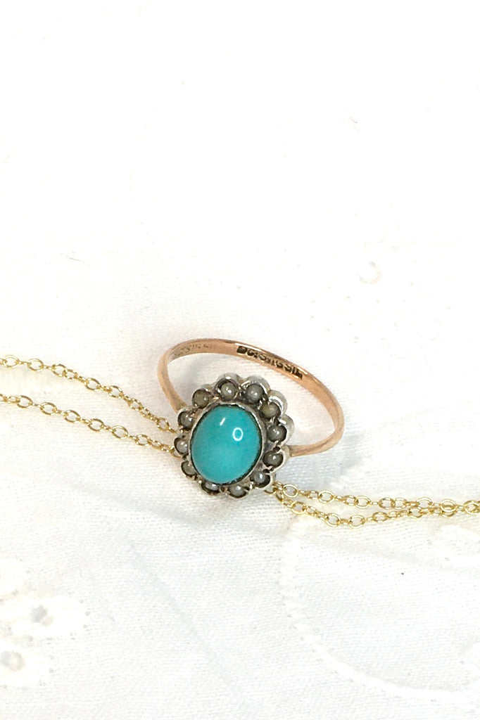 This Vintage with a solid turquoise centre stone has a surround of old 1/2 pearls, this ring has a fine band in 9ct gold. 