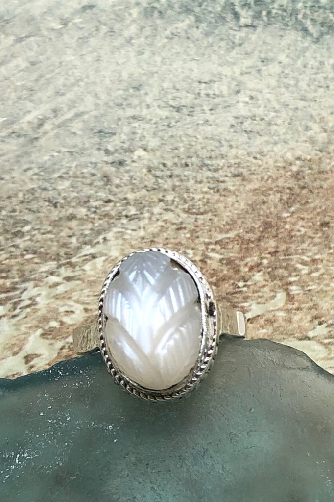 The Echo Ring Moonstone Carving is a handmade moonstone cabachon ring featuring set in silver with a hand carved leaf design.