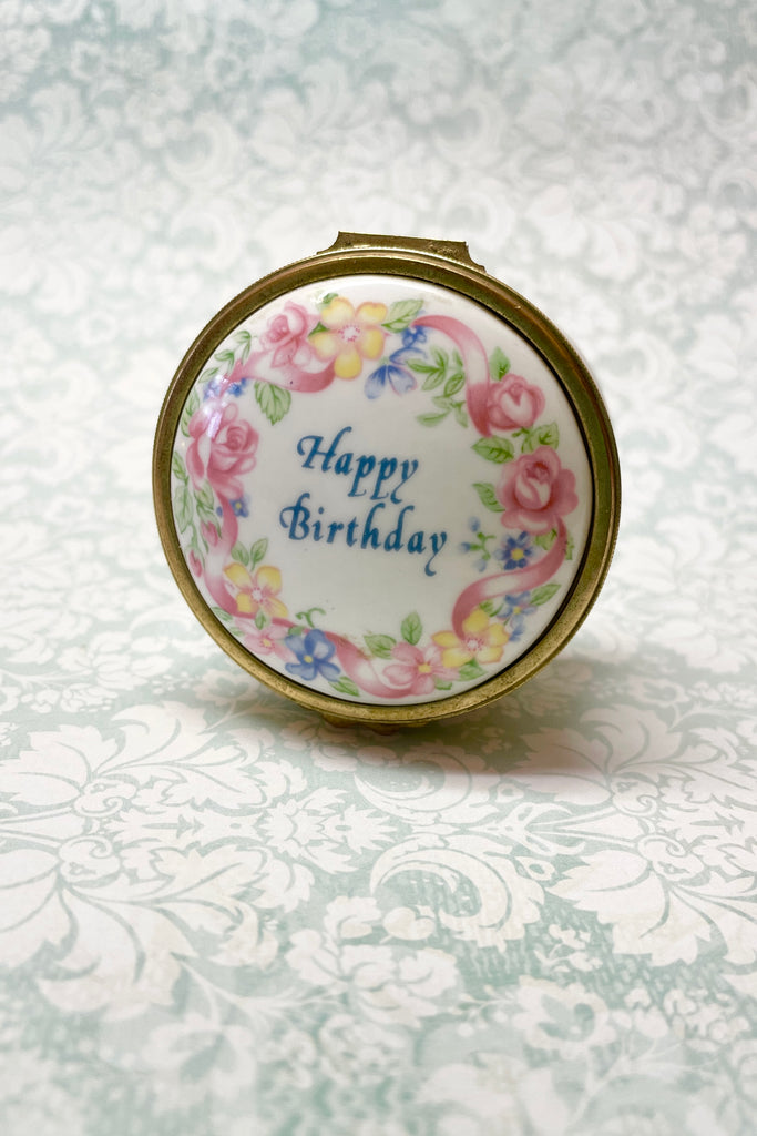 A pretty English bone china gift box, decorated with flowers it has a hinged lid. Happy Birthday box.