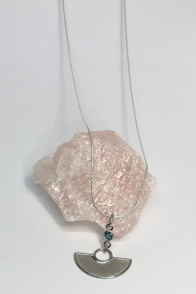 A stunning African Style 925 silver pendant with a Tourmaline Shard which hangs perfectly through a silver circle. The intense blue Tourmaline was sourced ethically from miners in Nigeria,