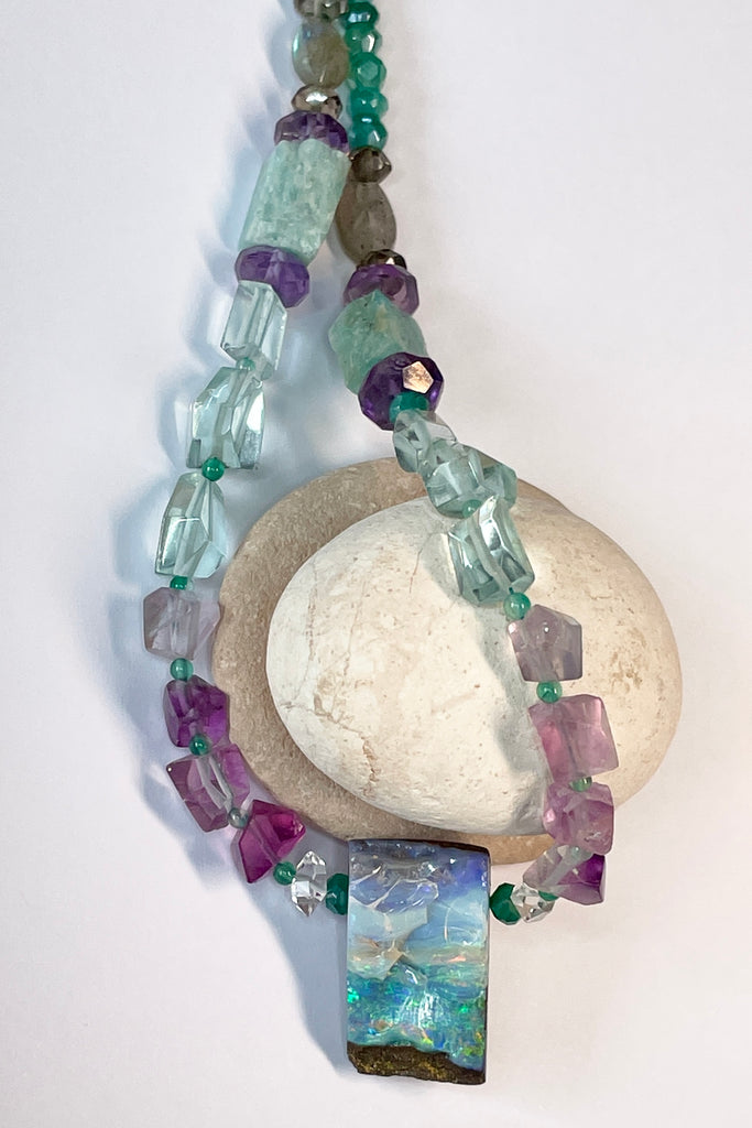 Opal necklace  The centrepiece is cut from an opal "split" so the surface is not polished but left exactly as it has been for millions of years. the back and sides are curved and polished to a soft shine. Bright flashes of crystal blue, green and mauve 