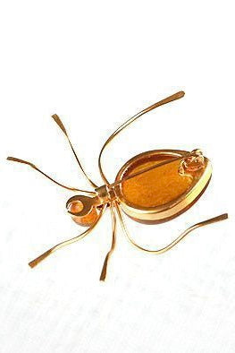 Features the form of a six legged bug with the head and body set with cabochons of natural Baltic honey amber. Marked on underside. A super quirky insect brooch