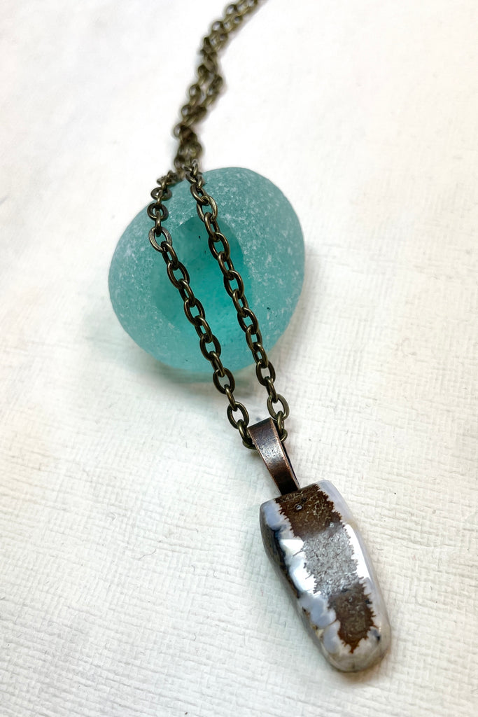  The pendant has a band of rock running down the centre and the edges have a crystalline opal edge.