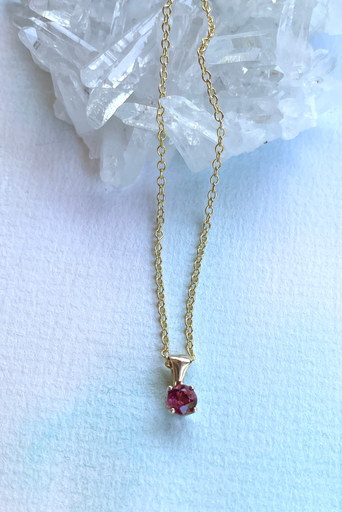 This adorable Luna pendant is made in 9ct gold, the stone is a lovely dark pink 4mm Tourmaline gemstone. A tiny delicate and sophisticated gemstone pendant.