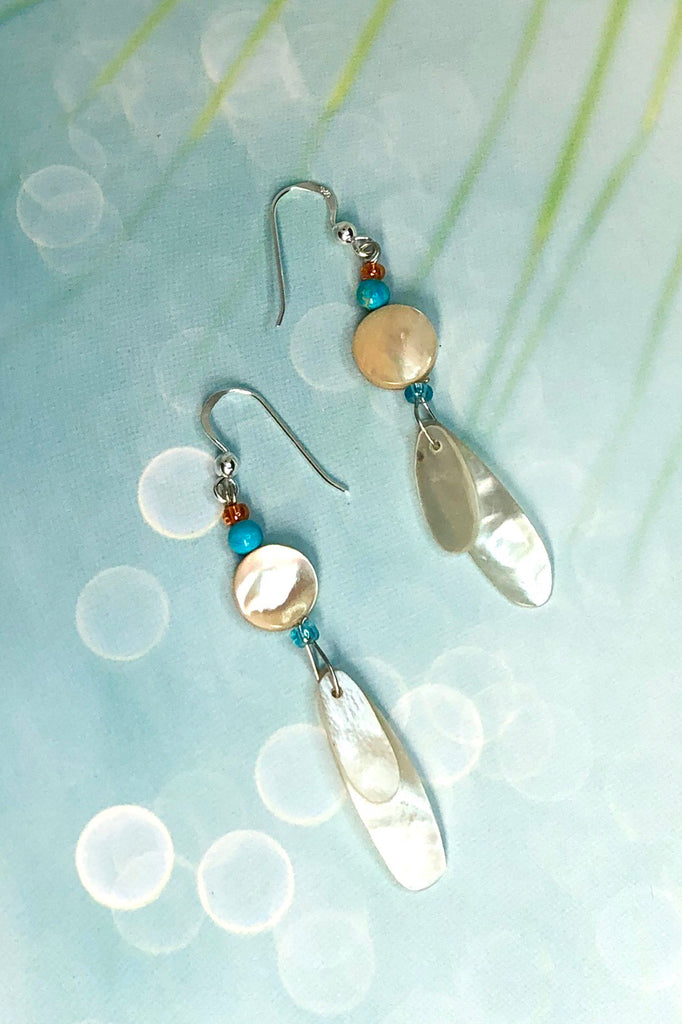 earrings Cay Antika Blue are a sweet little flutter of Mother of pearl shell, topped with a shell bead ans a turquoise Howlite bead. On a 925 silver hook. 