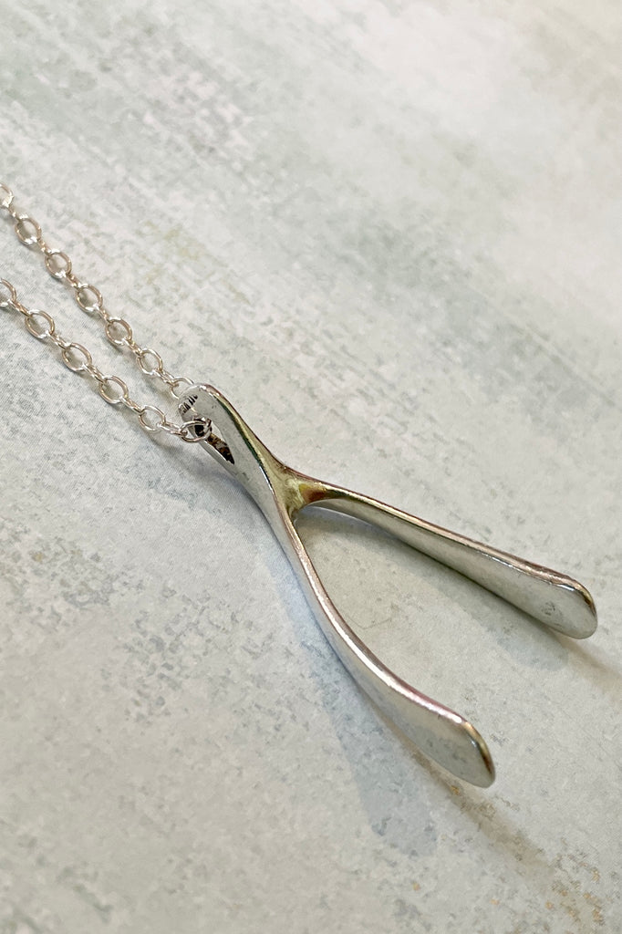 A small silver wishbone pendant, this is a vintage piece 