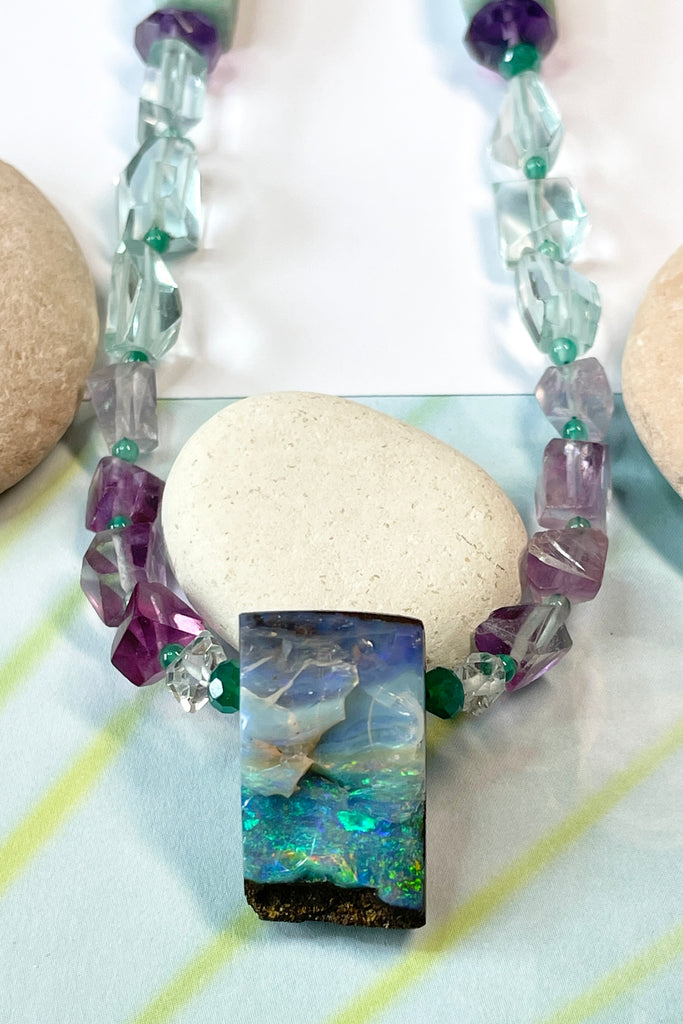 Opal necklace  The centrepiece is cut from an opal "split" so the surface is not polished but left exactly as it has been for millions of years. the back and sides are curved and polished to a soft shine. Bright flashes of crystal blue, green and mauve 