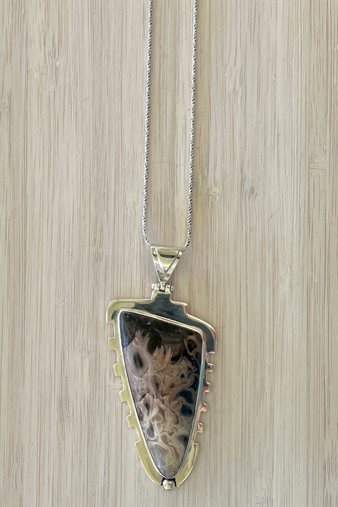 An intriguing fossilized wood pendant reflecting the history of an ancient forest. A modernist setting in a unique design